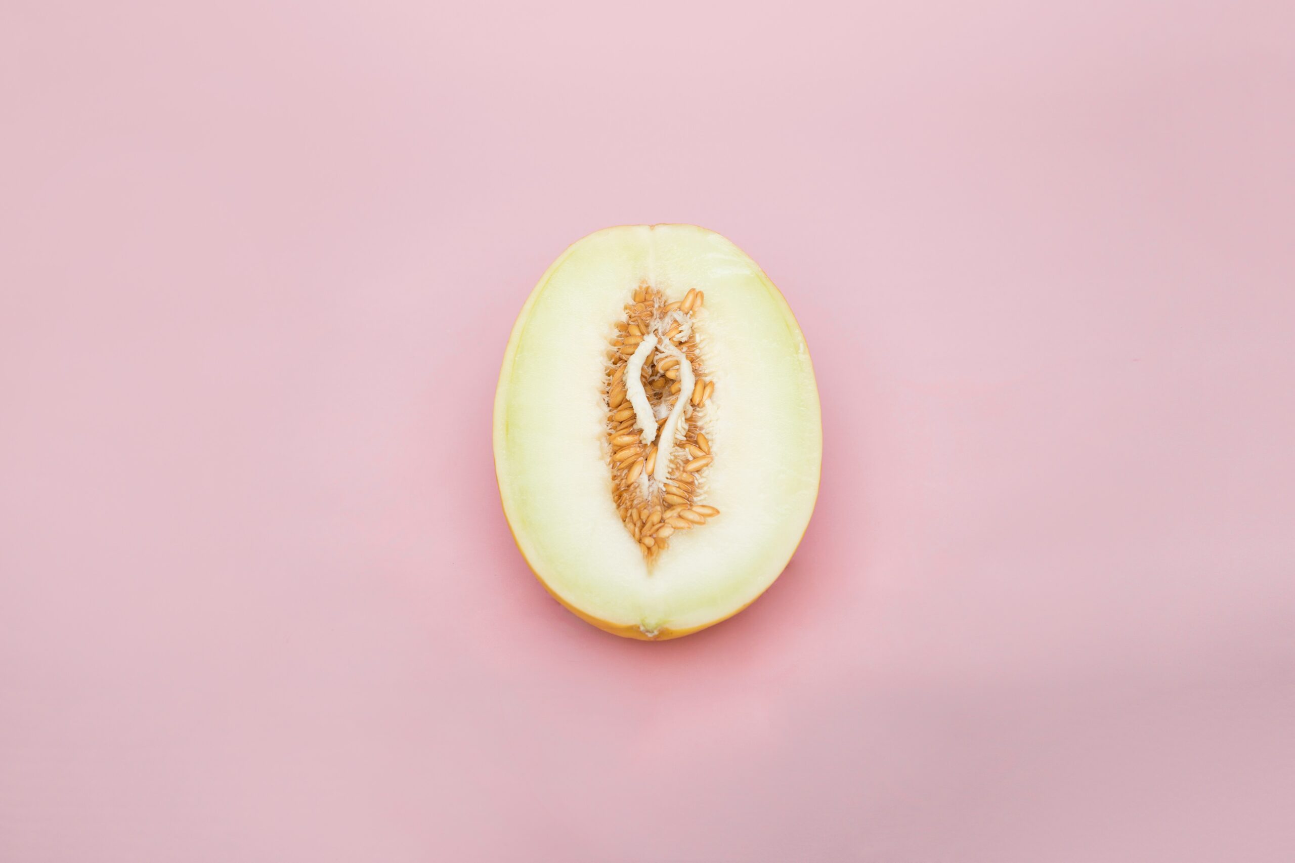 sliced yellow fruit on pink surface