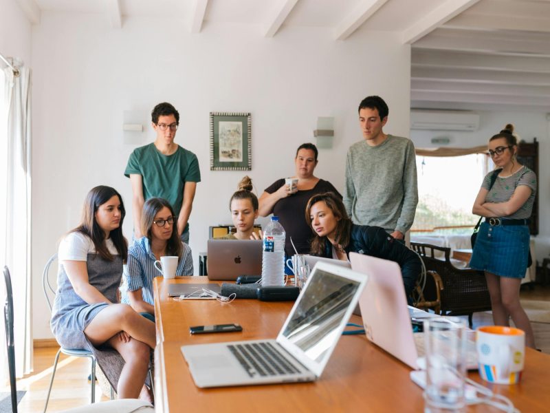 Group of young professionals engaged in a collaborative meeting in a modern office setting.