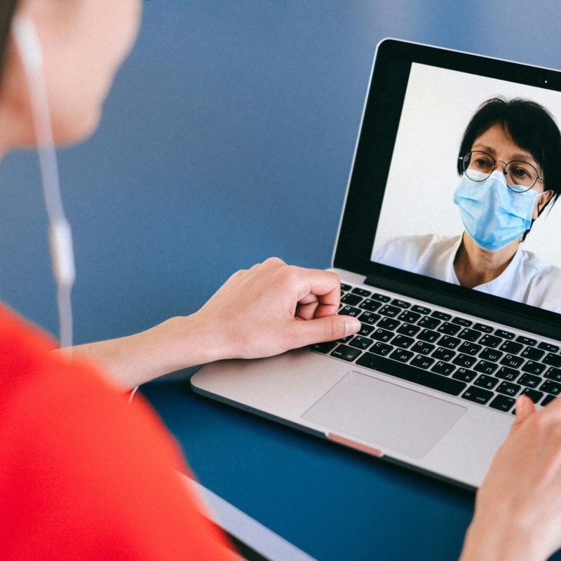 Doctor and patient on a video call for telehealth consultation during COVID-19 era.